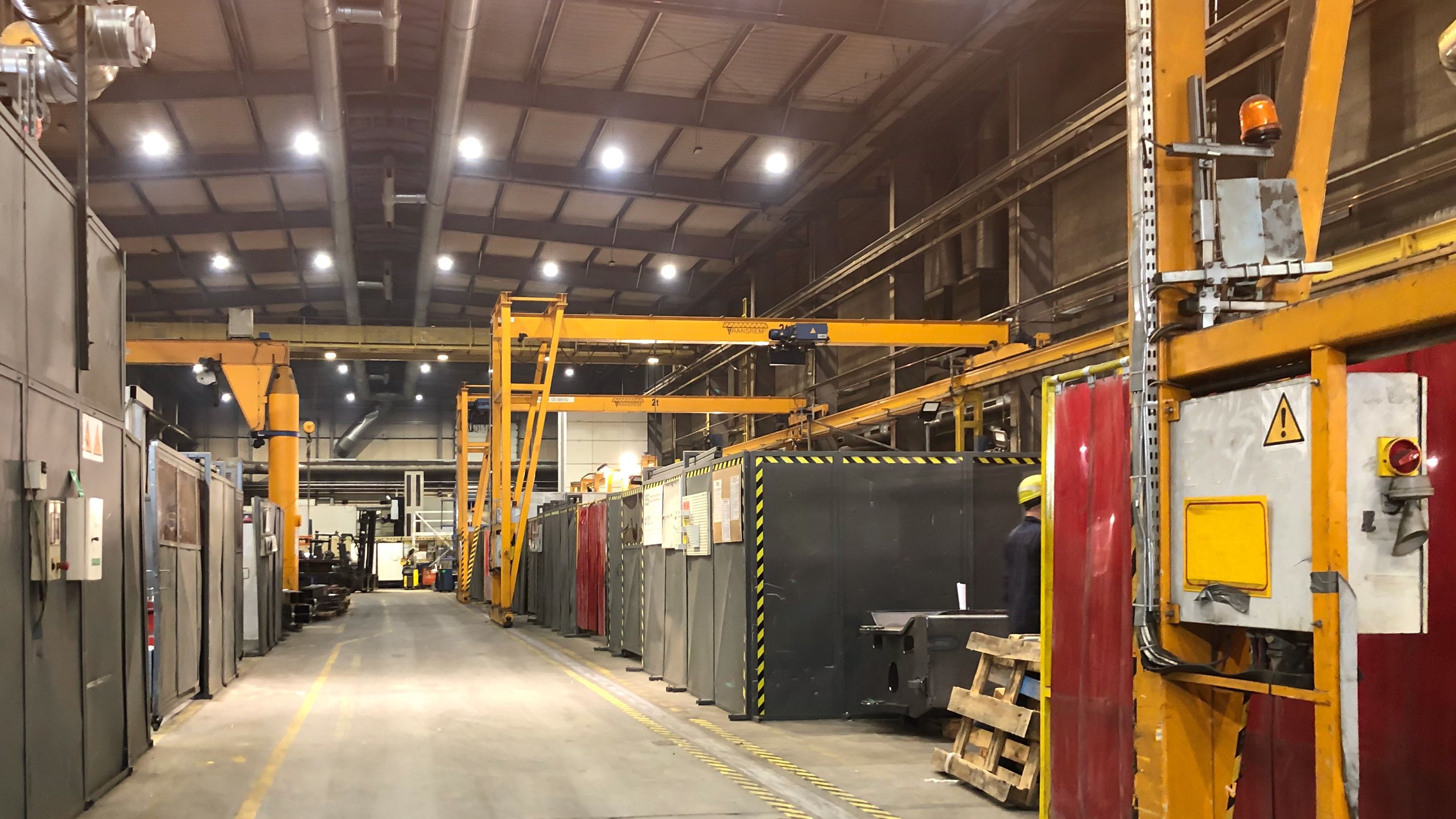 Varios puentes grúa instalados en una planta industrial: semipórticos y grúa de bandera en la nave